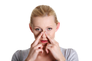 Young woman placing her fingers on the sides of her nose